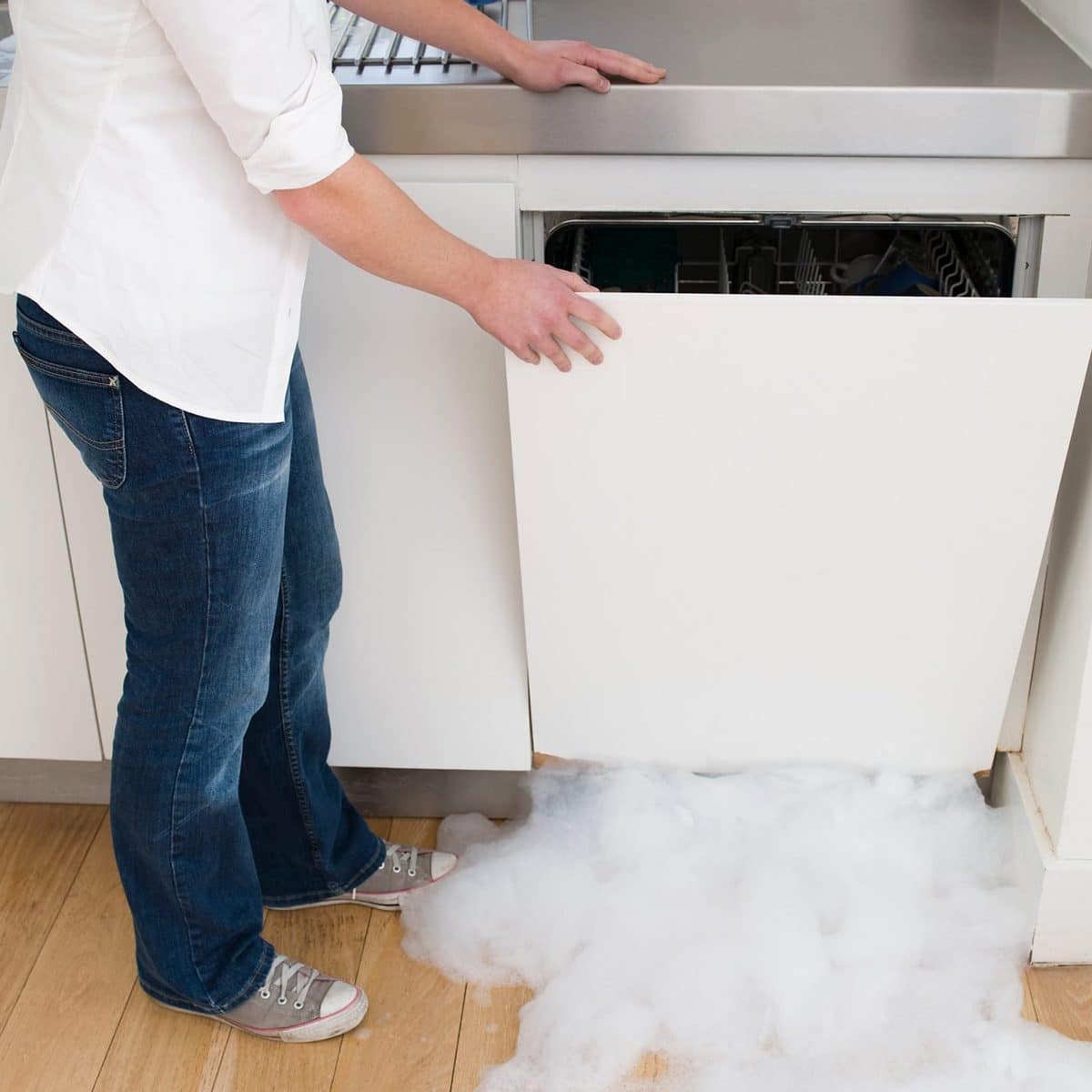 Woman opening a leaking dishwasher